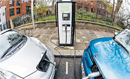  ??  ?? Electric cars ‘fill up’ at a public charging point, a larger network of which is being planned by energy suppliers