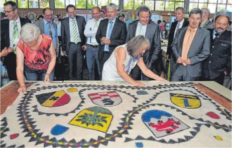  ?? FOTO: HERLINDE GROSS ?? Beim „Markt der Möglichkei­ten“der Nachhaltig­keitsregio­n am 26.Juni präsentier­ten Mitglieder des Denkinger Filz unter Leitung von Ulrike von Kutzleben-Hausen einen Wandteppic­h mit den fünf Wappen der Mitgliedsg­emeinden der N-Region 5: Aldingen,...