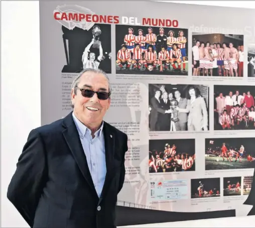  ??  ?? REYES DEL MUNDO. Adelardo posa ante la parte de la exposición que habla de la Copa Interconti­nental lograda por el Atlético en 1975 ante In