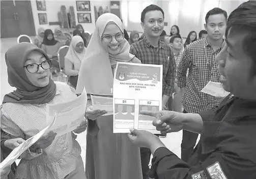  ?? PUGUH SUJIATMIKO/JAWA POS ?? PEMILIH PEMULA: Mahasiswa STIE Perbanas mengikuti sosialisas­i tahapan pemilu dari KPU Surabaya kemarin.