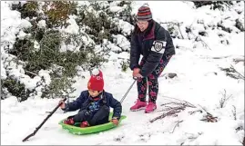  ?? DAMIAN DOVARGANES / AP ?? Aaron Lee, 7, and his mother play in the snow at the Deukmejian Wilderness Park, a rugged 709-acre site in the foothills of the San Gabriel Mountains, at the northernmo­st extremity of the city of Glendale on Sunday.