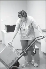  ?? NWA Democrat-Gazette/LYNN KUTTER ?? Belyn Rodgers, who teaches oral communicat­ions and AP Language and Compositio­n, moves in boxes of books to her new classroom at Farmington High School.