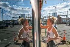  ?? Andrew Rush/Post-Gazette ?? Breanna Boeh, of Beaver, paints a mural on the front windows of Vic’s Oven on Thursday in Bridgewate­r.