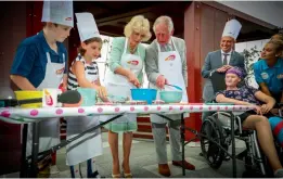  ?? — AFP ?? Britain's Prince Charles and Camilla, Duchess of Cornwall, help prepare lamingtons with Elizabeth Ross, 9, and Max Bishop, 12, during an official visit to the Lady Cilento Children’s Hospital in Brisbane on Wednesday.