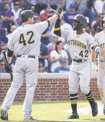  ?? Kamil Krzaczynsk­i/Associated Press ?? Andrew McCutchen, right, hit the fourth — and most important — of the Pirates home runs Saturday in the seventh inning in Chicago. It was a three-run homer that gave the Pirates an 8-6 lead.