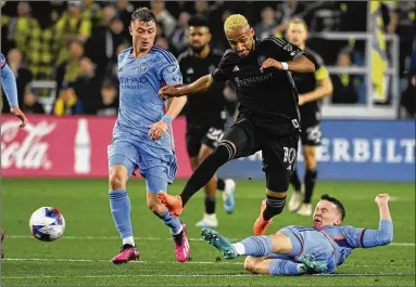  ?? MARK ZALESKI/ASSOCIATED PRESS ?? New York City FC defender Mitja Ilenic slides while kicking the ball away from Nashville SC midfielder Hany Mukhtar (10) during the second half of Saturday’s Nashville win. Mukhtar is the reigning league MVP.