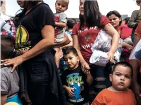  ?? NEW YORK TIMES PHOTOS BY TODD HEISLER ?? A group of immigrants from Central America, who were detained after entering the U.S., walk away after being released at a bus station June 22 in McAllen, Texas. Many were given ankle monitors and notices to appear in court.