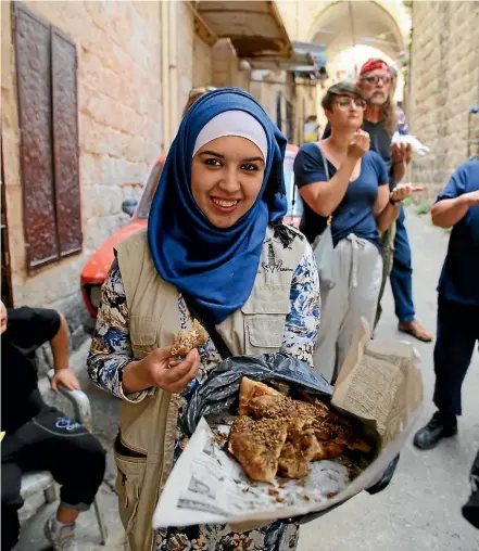  ?? PHOTO: BEN GROUNDWATE­R ?? Lana, one of the volunteers at Bait al Karama, offers up some fresh baked bread with za’atar.