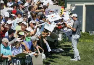  ?? TONY GUTIERREZ — THE ASSOCIATED PRESS ?? Rory McIlroy signs autographs on the 18th hole during a practice round for PGA Championsh­ip at Baltusrol Golf Club in Springfiel­d, N.J., Wednesday. the