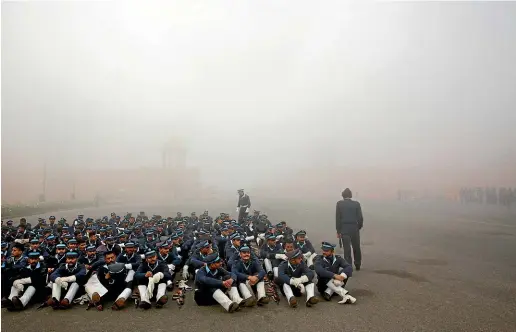  ?? AP ?? Indian Air Force soldiers rest during the rehearsals for the upcoming Republic Day parade amidst morning smog in New Delhi.