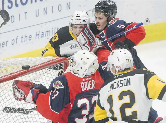  ?? SCOTT GARDNER/THE HAMILTON SPECTATOR ?? Spitfires goaltender Brock Baier scrambles to grab a loose puck as the Bulldogs’ Zachary Jackson swoops in at FirstOntar­io Centre Sunday in Hamilton.