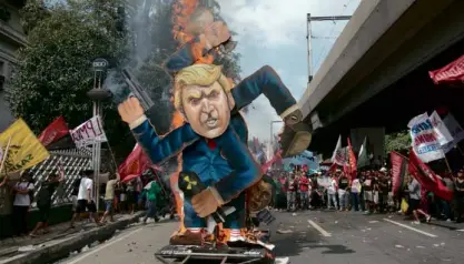  ?? INQUIRER PHOTO/ ALEXIS CORPUZ ?? Protesters burn an effigy of US President Donald Trump on Taft Avenue in Manila on Nov. 13. Trump capped off his 12-day, five-nation Asia tour that included Japan, South Korea, China and Vietnam with his visit to the Philippine­s to attend the Asean...