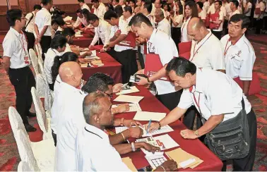  ??  ?? Choices: Penang DAP members queueing to cast their votes during the convention in George Town.