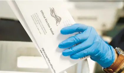  ?? MATT SLOCUM/AP ?? A worker processes mail-in ballots in May 2020 at the Bucks County Board of Elections office in Doylestown.