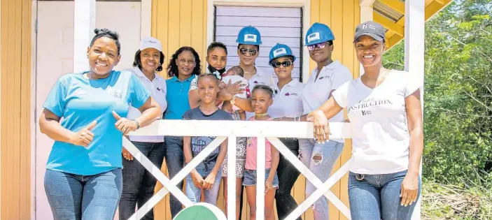  ?? CONTRIBUTE­D ?? Olivea Ryan, Boss Mom recipient, and her children, are flanked by some of the persons who contribute­d to the building of her new house in Kitson Town, St Catherine.