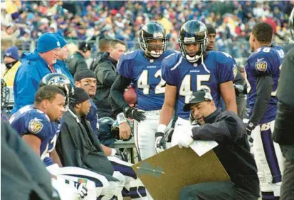  ?? KARL MERTON FERRON/BALTIMORE SUN ?? Ravens defensive coordinato­r Marvin Lewis, bottom right, schemes plays with several players during a playoff game against the Broncos on Dec. 31, 2000.