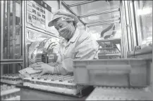  ?? LI BO / XINHUA ?? An employee from Panasonic Energy (Wuxi) Co Ltd works on a battery production line at the company’s workshop in Wuxi, Jiangsu province, in July.