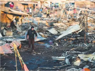  ??  ?? Firefighte­rs work amid the debris left by a huge blast that destroyed a fireworks market in a suburb of Mexico City and killed at least 29 people. Ronaldo Schemidt, AFP/Getty Images