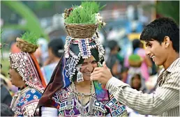  ??  ?? A man shows a woman her picture on a phone taken during the celebratio­n of Teej festival by Lambada women at Bathukamma ghat at Tank bund on Sunday.