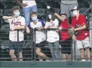  ?? CURTIS COMPTON — ATLANTA JOURNAL-CONSTITUTI­ON VIA AP ?? Fans in center field catch home run balls while the Atlanta Braves take batting practice before playing the Los Angeles Dodgers in Game 1of the National League Championsh­ip Series on Monday, Oct. 12, in Arlington, Texas.