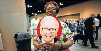  ?? /Reuters ?? Cooling off: A shareholde­r waves herself with a fan that bears an image of billionair­e Warren Buffett on Friday at the annual meeting in Omaha, Nebraska, of leading US investment group Berkshire Hathaway.