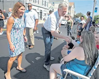  ?? NANCY LANE / BOSTON HERALD FILE ?? VOTE-BUYING? Gov. Charlie Baker and Lt. Gov. Karyn Polito greet people Sept. 3 during the Labor Day parade in Marlboro.