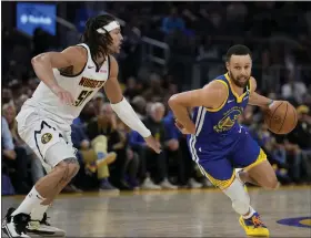  ?? GODOFREDO A. VÁSQUEZ — THE ASSOCIATED PRESS ?? Warriors guard Stephen Curry, right, moves the ball while defended by Nuggets forward Aaron Gordon during the second half Sunday in San Francisco.