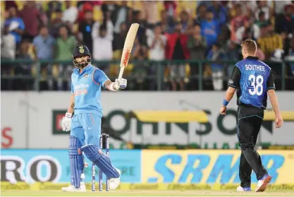  ?? — AFP ?? DHARAMSALA: Indian batsman Virat Kohli raises his bat after completing a half century (50 runs) during the first one day internatio­nal match between India and New Zealand at The Himachal Pradesh Cricket Associatio­n Stadium (HPCA) in Dharamsala yesterday.