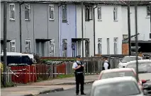  ??  ?? Police officers stand behind cordon tape near a property in Sunbury-on-Thames that was searched after an explosion on a London Undergroun­d train.