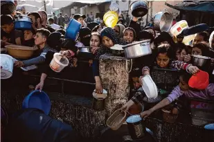  ?? Fatima Shbair/Associated Press ?? Palestinia­ns line up for a free meal in Rafah, Gaza Strip, on Tuesday. Aid groups say it is nearly impossible to deliver aid in much of Gaza because of ongoing hostilitie­s.