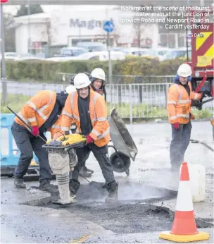  ?? JAMES DAVIES ?? Workmen at the scene of the burst water main at the junction of Ipswich Road and Newport Road in Cardiff yesterday