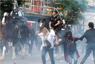  ?? Pictures: GETTY ?? Terrence Floyd, brother of George, who died in custody, appealed for calm, far left, tear gas is washed away from the eyes of a protester, left, and, right, police horses charge in the capital