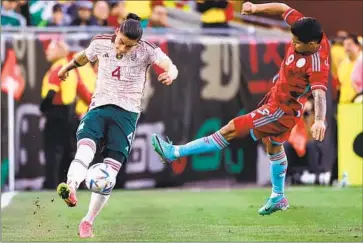  ?? Omar Vega Getty Images ?? ALEXIS PEÑA of Mexico tries to send a pass toward the middle of the field as Colombia’s Cucho Hernández pressures him. Mexico lost a 2-0 lead as Colombia scored three second-half goals in a 3-2 win at the Coliseum.