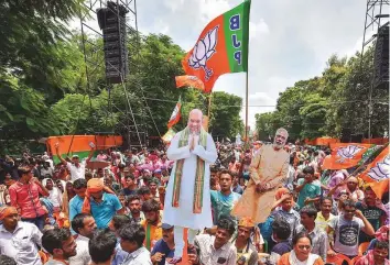  ?? PTI ?? BJP activists hoist cut-outs of party leaders Amit Shah and Narendra Modi during a public rally in Kolkata yesterday. Addressing the rally, Shah came down heavily on the West Bengal’s ruling party, accusing it of being involved in a series of corruption cases