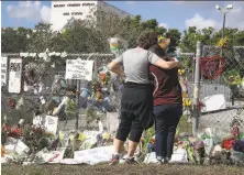  ?? Joe Raedle / Getty Images ?? Marjory Stoneman Douglas High School employees Joellen Berman (left) and Margarita Lasalle visit the campus Friday.