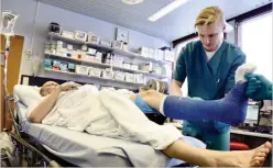  ?? / HEIKKI SAUKKOMAA
FOTO: LEHTIKUVA ?? BENBROTT. Medikalvak­tmästare Niko Lempinen lägger gips på en halkskadad mans fot Tölö sjukhus olycksfall­sstation.
