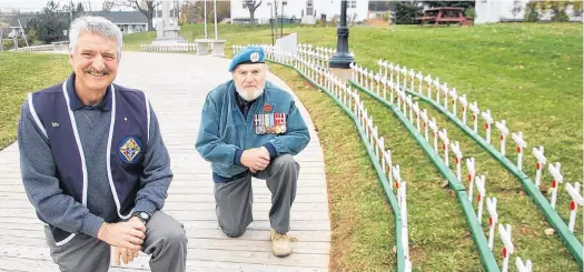  ?? JIM DAY/THE GUARDIAN ?? James Donnelly, grand knight of the Knights of Columbus (K of C) Father McNeill Council 9025, left, and K of C member Simon Lemay pose by the impressive display of wooden crosses that pay tribute to 420 late veterans buried in the North Rustico area.