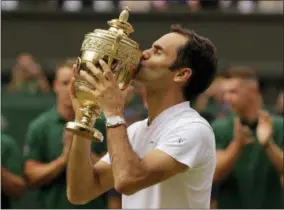 ?? ALASTAIR GRANT — THE ASSOCIATED PRESS FILE ?? In this file photo, Switzerlan­d’s Roger Federer kisses the trophy after defeating Croatia’s Marin Cilic to win the Men’s Singles final match at the Wimbledon Tennis Championsh­ips in London. When play begins at Wimbledon on Monday Federer will have the...