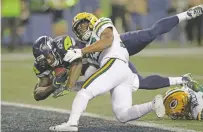  ?? STEPHEN BRASHEAR ASSOCIATED PRESS ?? Seahawks tight end Ed Dickson, left, dives past the Packers Ibraheim Campbell to score a touchdown Thursday in Seattle.