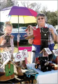  ?? RITA GREENE/MCDONALD COUNTY PRESS ?? Paige Corter, left, and Pam Thulin selling unique handmade purses and birdhouses at the Goodman Ozark Orchard Festival Saturday. Thulin designs the items and said they are made of leather. The purses are made from cowboy boots. Both Thulin and Corter...