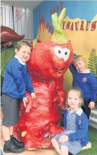  ??  ?? Reception class children (from left) Gabe Adamson, Maeve Busby and Harry Price with the Spottyosau­rus they helped make