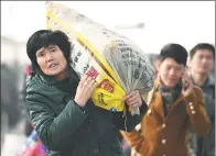  ?? LIU QINLI / FOR CHINA DAILY ?? A passenger carries her luggage as she heads home for Lunar New Year celebratio­ns at a railway station in Bozhou, Anhui province, on Thursday.