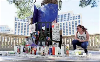  ?? MARCIO JOSE SANCHEZ / ASSOCIATED PRESS ?? Allison Easterbroo­ks pauses at memorial for the 58 people killed in Sunday’s shooting in Las Vegas by a sniper armed with almost two dozen weapons. US President Donald Trump visited survivors and met with first responders on Wednesday.