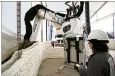  ??  ?? An employee works to build a 3D printed social housing building called ‘Yhnova’, using a constructi­on 3D printing technique known as BatiPrint3­D. — Reuters