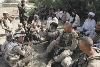  ?? David Guttenfeld­er / Associated Press 2009 ?? Josh Habib (left), a translator for U.S. forces, speaks with villagers and two Marines in Afghanista­n’s Helmand Province in 2009. More than 200 Afghans arrived in Virginia on Friday.