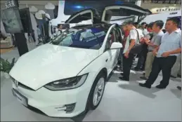  ?? PROVIDED TO CHINA DAILY ?? Visitors check out a Tesla intelligen­t car displayed at the 2017 Seventh China Smart City Technology and Applicatio­n Products Expo in Ningbo, Zhejiang province, on Sept 8.