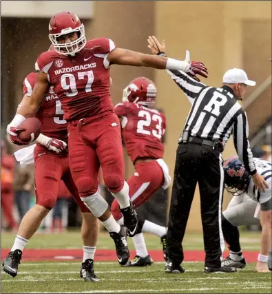  ?? NWA Media/MICHAEL WOODS ?? Arkansas defenders Tevin Beanum (97) and Brooks Ellis (behind Beanum) celebrate Beanum’s recovery of a fumble by Bo Wallace in the second quarter of the Razorbacks’ 30-0 victory Saturday at Razorback Stadium. Wallace (far right) injured his ankle on...