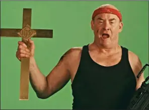  ??  ?? In the parody “Faith-Ba$ed,” David Koechner stars as Butch Savage, an ’80s action star who takes on the role of God in a cynical movie made by two 30-something Los Angelenos to cash in on the demand for Christian-theme films.