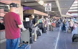  ?? Steve Marcus
Las Vegas Sun ?? CHECK-IN LINES stretch along the departure curb at McCarran Internatio­nal Airport in Las Vegas. Southwest Airlines said it had not yet solved the glitch.