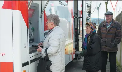  ?? TIMM SCHAMBERGE­R / AGENCE FRANCE-PRESSE ?? A customer withdraws money from a cash machine at a mobile office bus of the savings bank Sparkasse in Tschirn, southern Germany, on Jan 30.
